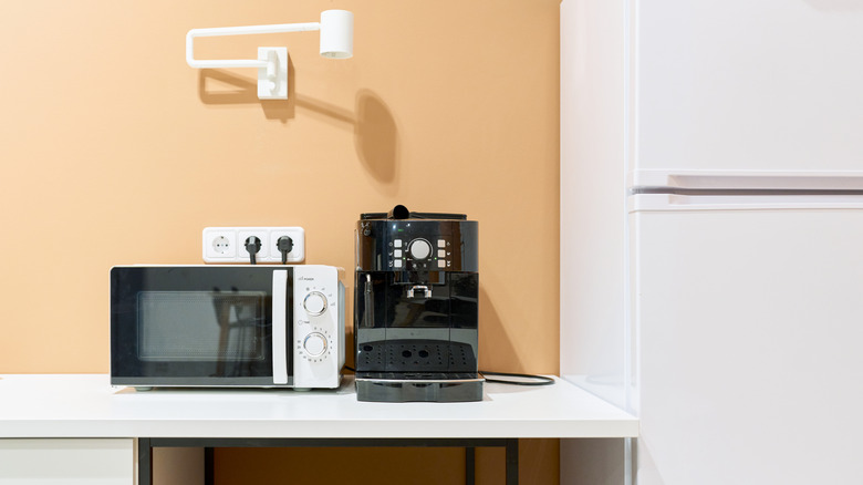 Microwave and coffee machine plugged into power source