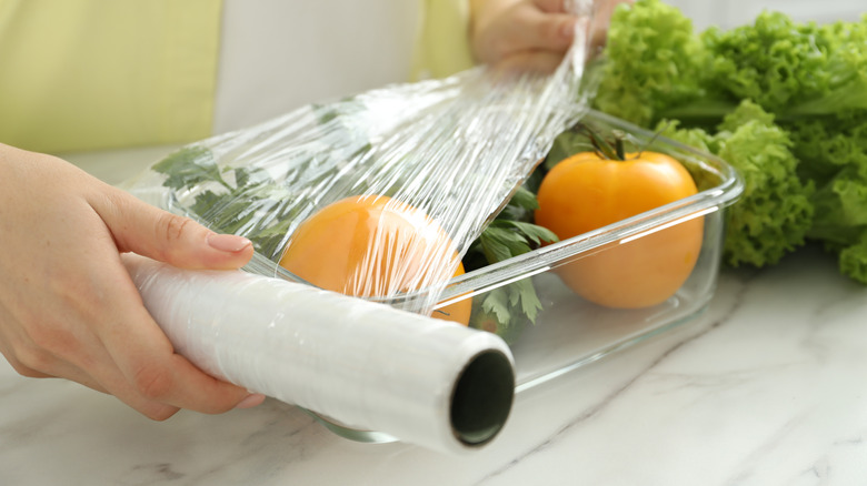 Putting plastic food wrap over glass container