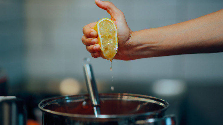squeezing lemon juice into pan