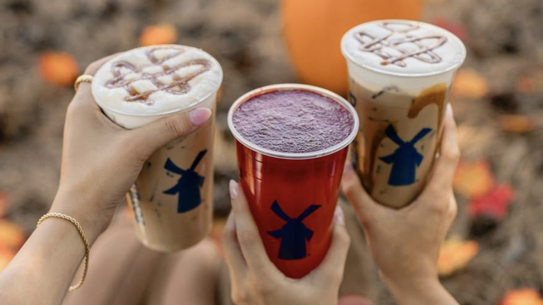 three Dutch Bros drinks in fall setting