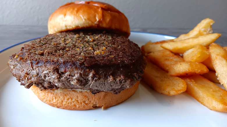 Burger with a bun and fries from Cracker Barrel on a white plate