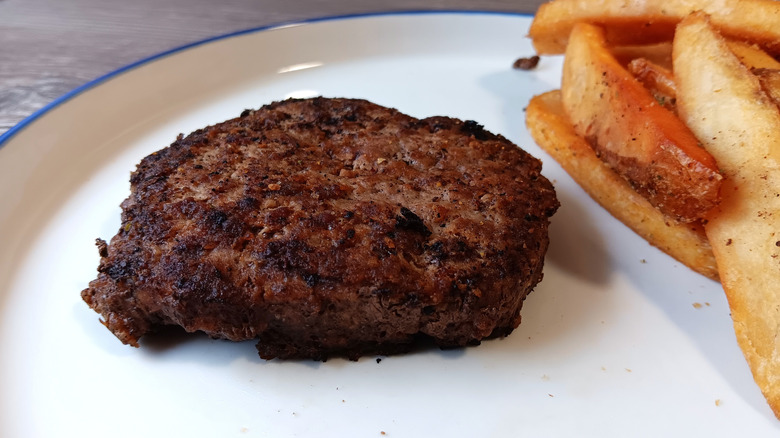 Burger patty and fries from Texas Roadhouse on a white plate