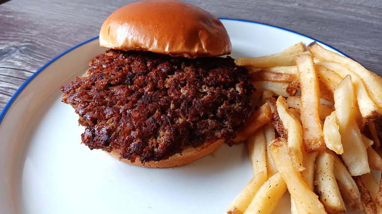 Applebee's burger on a bun with a side of fries on a white plate
