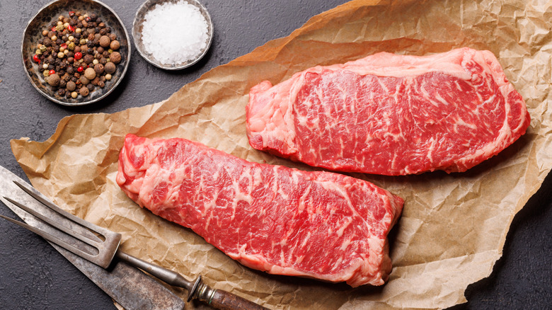 raw sirloin steaks on paper