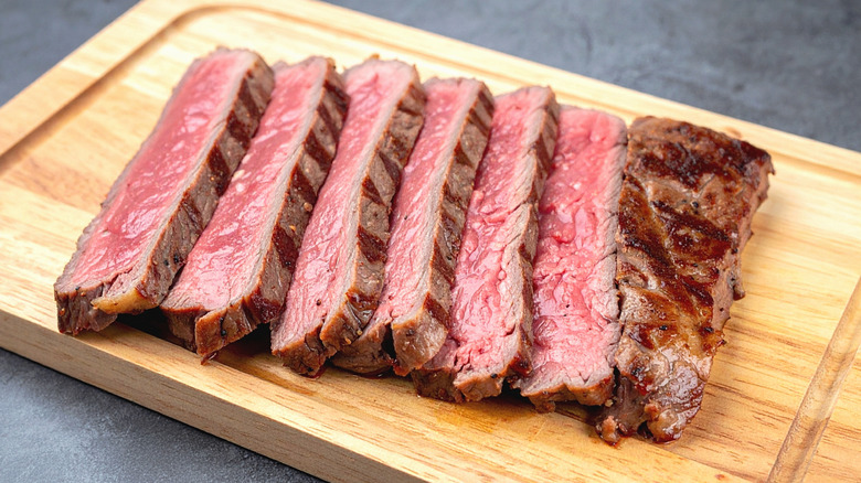 sliced thin steak on cutting board