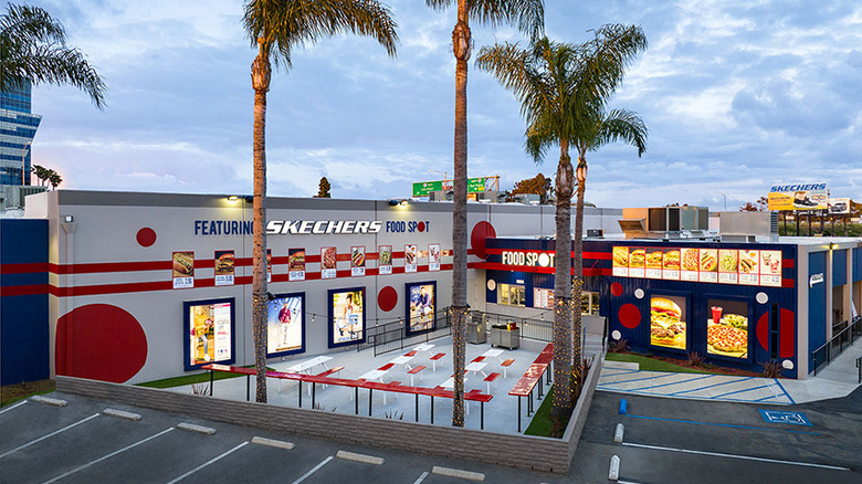 An outdoor view of the Skechers Food Spot cafe, showing seating and its menu