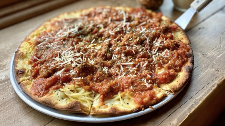 spaghetti pizza served on table