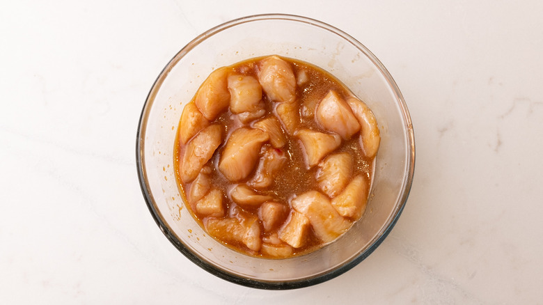 Raw chicken and marinade in bowl