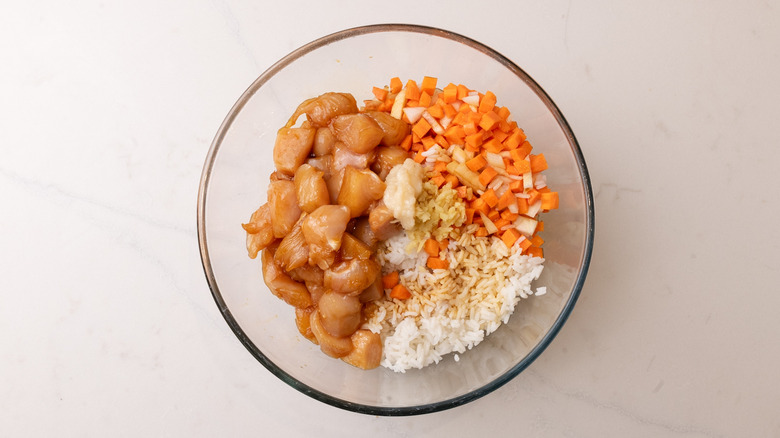 Chicken, rice, and other fried rice ingredients in bowl