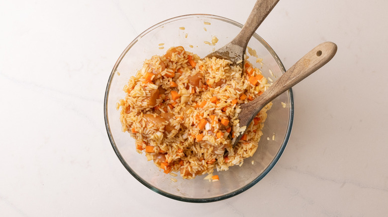 Rice, veggies, and chicken tossed together in bowl