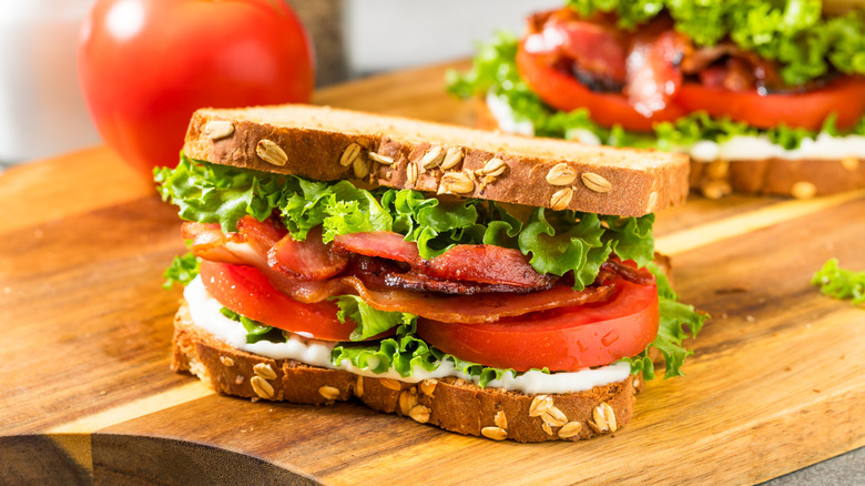 blt sandwich on wheat bread on wood table
