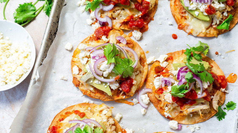 Baked chalupas on baking sheet with queso fresco on the side