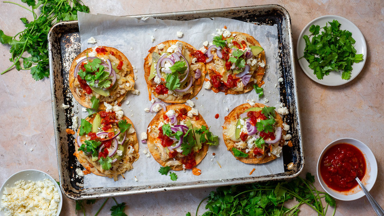 Dressed tortillas with all the toppings on baking sheet