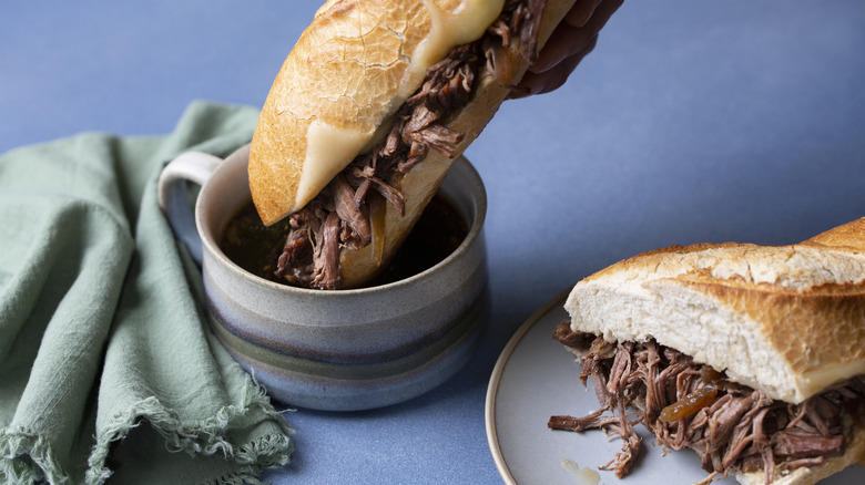 A French dip sandwich is dipped into dip