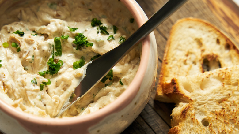 A bowl of French onion dip and bread slices