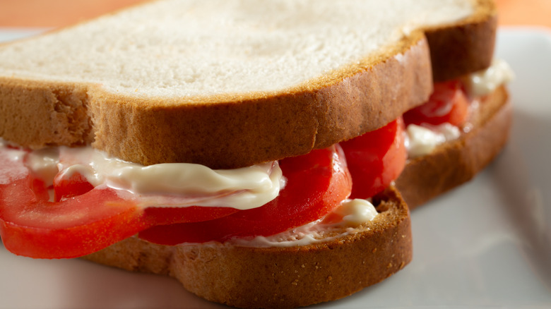 A tomato sandwich with mayo on white bread