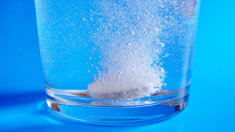 Close-up of Alka-Seltzer dissolving in glass of water