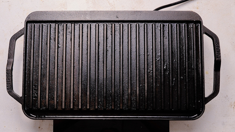 Aerial view of a cast iron grill preheating on a tabletop