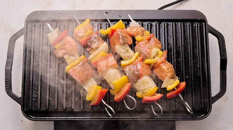 aerial view of smoky salmon kebabs cooking on a grill