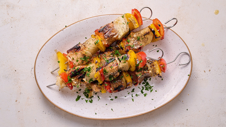 aerial view of salmon kebabs topped with parsley on a platter