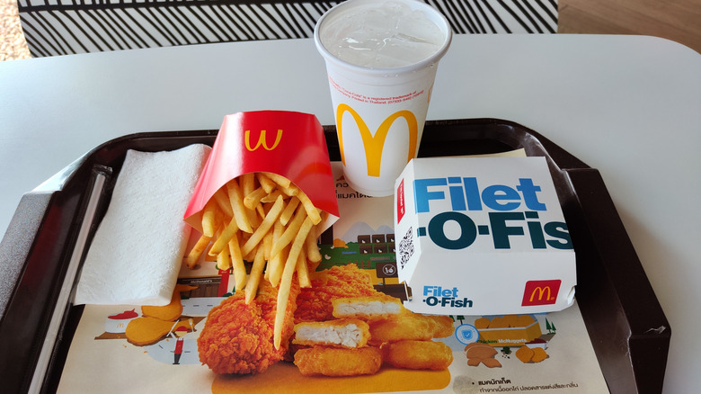 A Filet-O-Fish on a tray with a McDonalds Fry and a drink