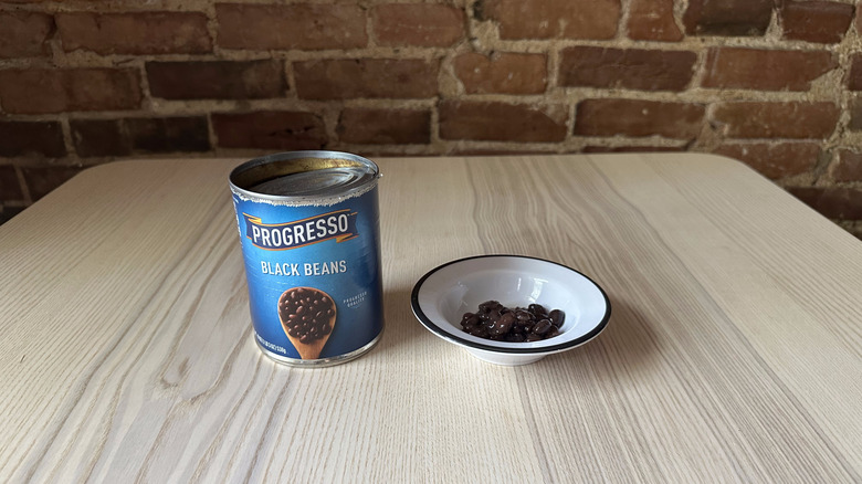 Can of Progresso black beans next to white bowlful