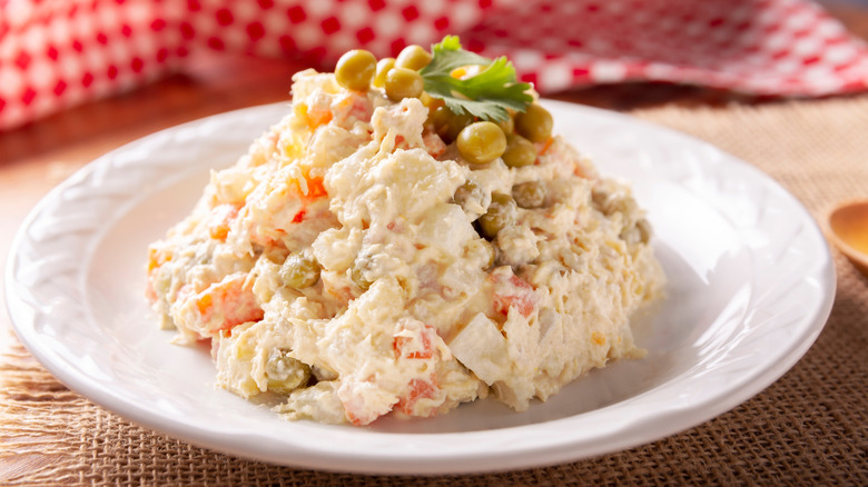 Mound of chicken salad with vegetables and mayonnaise garnished with capers