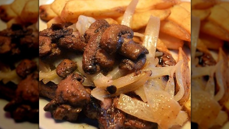 mushroom and onion coated steak with fries at Texas Roadhouse
