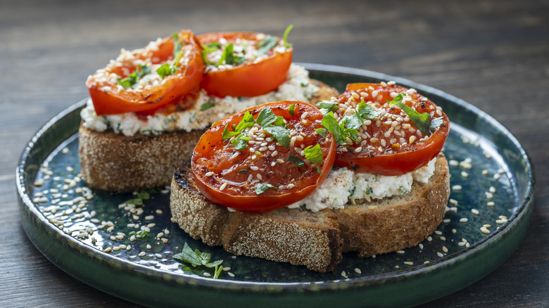 toasted crostini topped with creamy cheese and fresh tomato slices