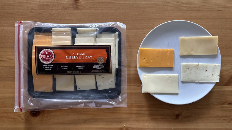Package of Primo Taglio sliced cheese on wooden table