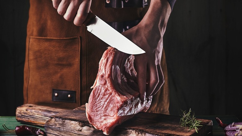 man slicing pork ribs
