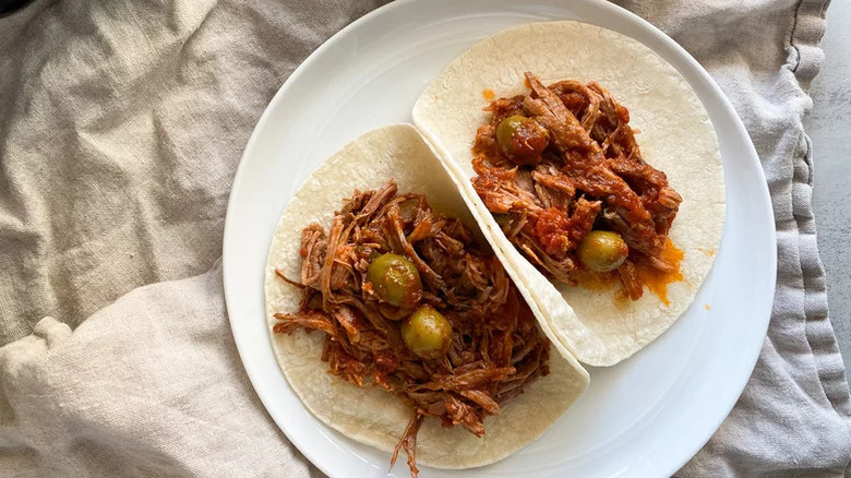 Pulled beef and olive tacos on a plate