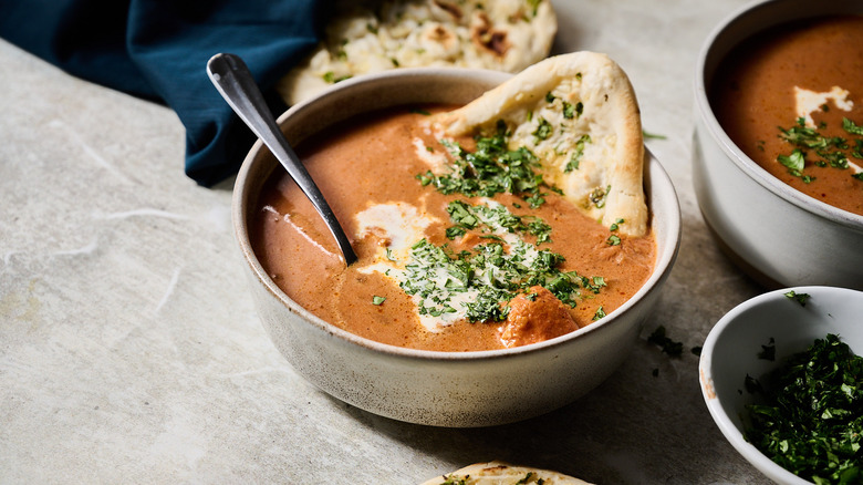 chicken tikka masala soup in bowl with naan