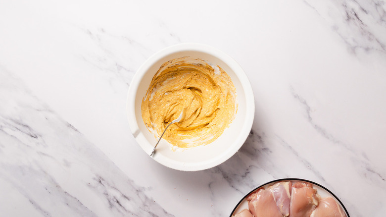 Marinade in large bowl beside chicken