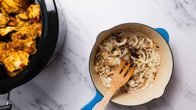 Cooked onion in pan besides slow cooker with chicken