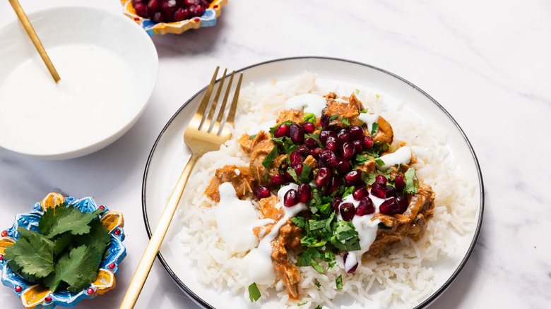 Plate with chicken tikka masala with yogurt and toppings