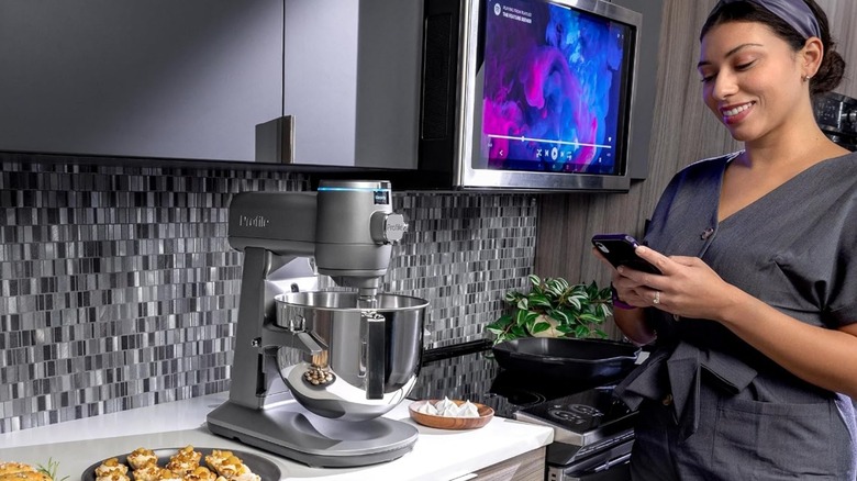 A women using a GE Profile Smart Mixer on kitchen counter