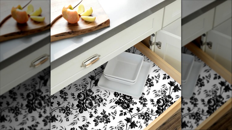 Floral self-adhesive shelf liner lines a drawer in a kitchen.
