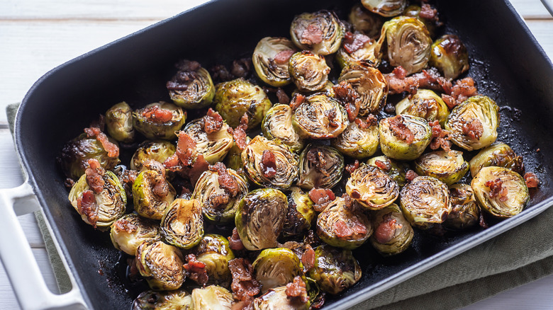A casserole dish filled with smoked Brussels sprouts and bacon