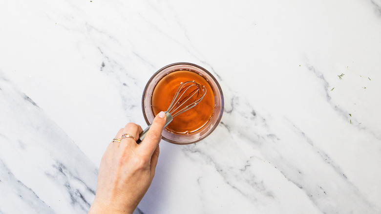 Whisking pickling liquid in small bowl.