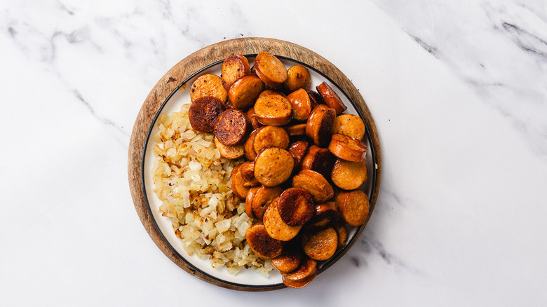 Cooked onions and crispy sausage in plate