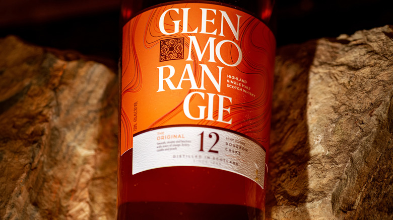 A close-up of a bottle of Glenmorangie 12-year placed on a rocky background