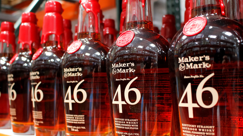 A line of several Maker's Mark 46 bottles on a liquor store shelf