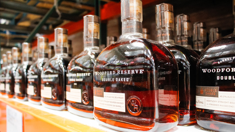 A large selection of Woodford Reserve Double Oaked bottles on a liquor store shelf