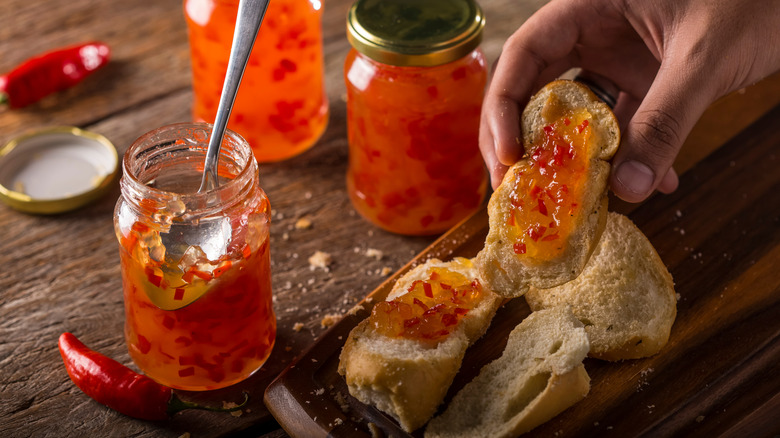 Jar of homemade pepper jam beside a slice of toast