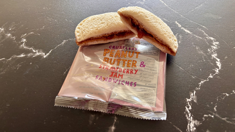 Trader Joe's crustless peanut butter and jelly sandwich wrapper with halved sandwich on top