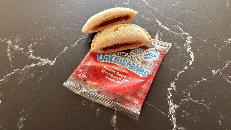 Uncrustables sandwich wrapper with halved Uncrustable on top