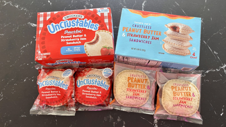 Smucker's Uncrustables box and Trader Joe's crustless peanut butter and jelly sandwich box next to wrapped Uncrustable sandwiches