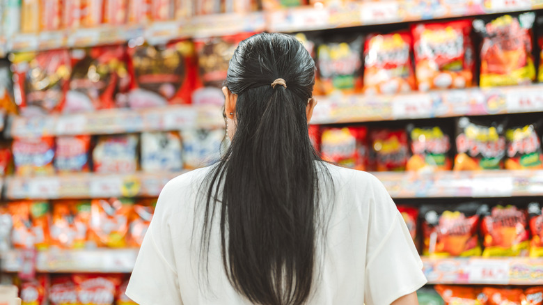 person standing in front of snacks in grocery store