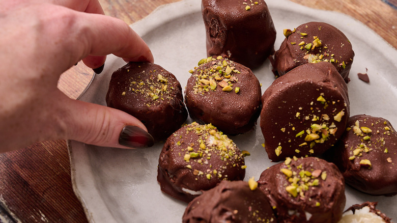 hand grabbing a banana off of the plate